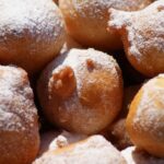 Frittelle dorate di ricotta e uvetta su un piatto, pronte per essere gustate.