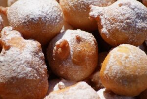 Frittelle dorate di ricotta e uvetta su un piatto, pronte per essere gustate.