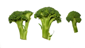 Broccoli freschi su un tavolo con un cartello che avverte sui potenziali effetti negativi.