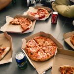 Fetta di pizza su un piatto, simbolo di un consumo occasionale e del benessere legato alla vitamina D.