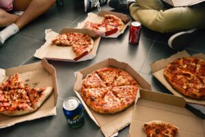 Fetta di pizza su un piatto, simbolo di un consumo occasionale e del benessere legato alla vitamina D.