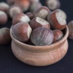 Nocciole su un tavolo con un bicchiere d'acqua, simbolo di salute e alimentazione equilibrata.