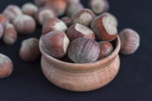 Nocciole su un tavolo con un bicchiere d'acqua, simbolo di salute e alimentazione equilibrata.