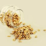 Ciotola di avena con frutta fresca e noci, ideale per una colazione salutare e povera di colesterolo.