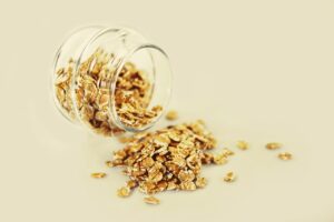 Ciotola di avena con frutta fresca e noci, ideale per una colazione salutare e povera di colesterolo.